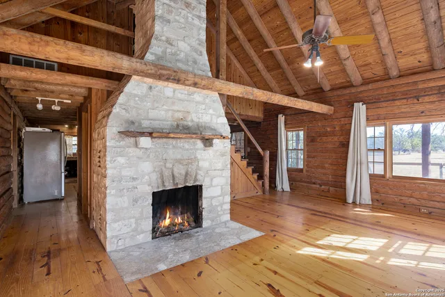 a living room with a fireplace furniture a ceiling fan and a rug
