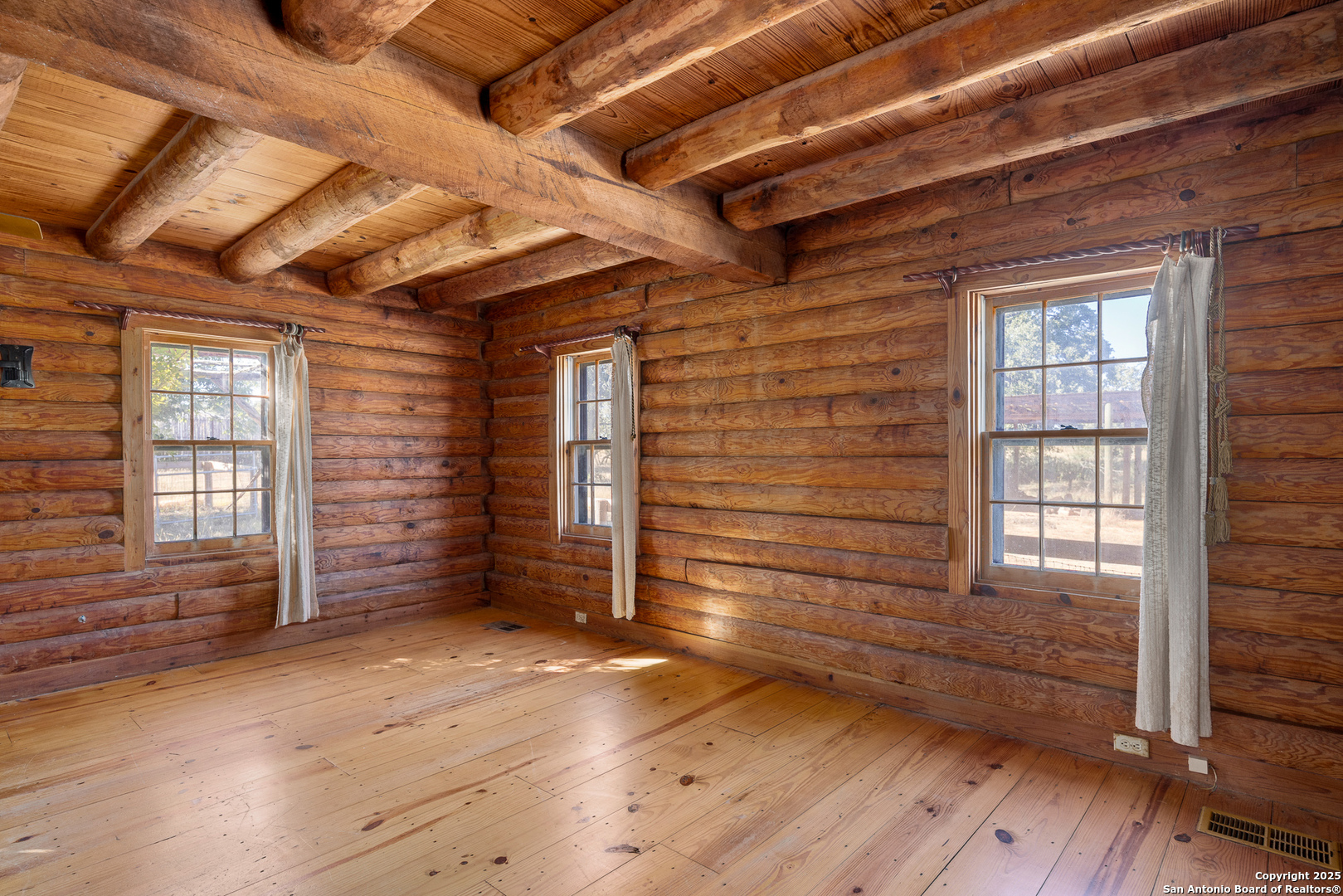 387 Schmidtzinsky Road Fredericksburg, TX 78624 - Photo 9 of 37 an empty room with wooden floor and windows