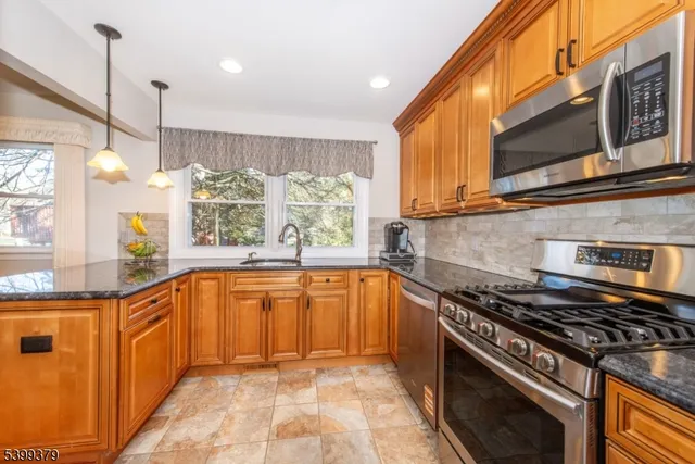 a kitchen with stainless steel appliances granite countertop a stove a sink and a microwave