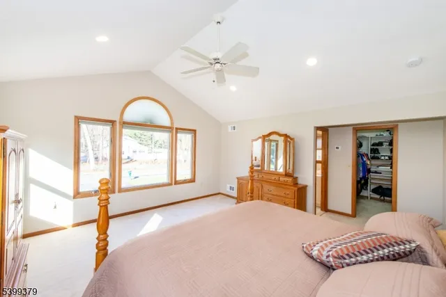a bedroom with a bed and a large window with the outer view