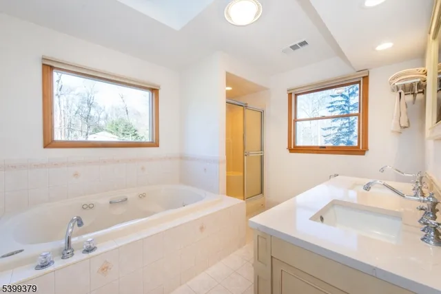 a bathroom with a tub sink and mirror