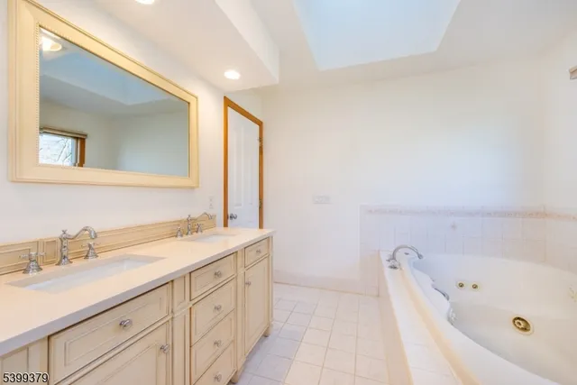 a bathroom with a tub sink and mirror