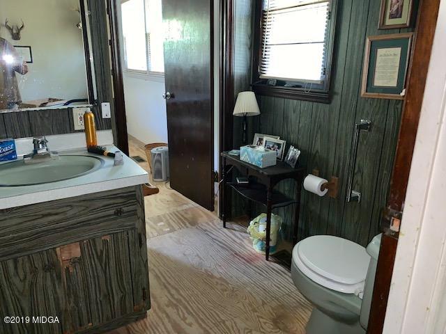 3229 Hamlin Road Lizella, GA 31052 - Photo 14 of 23 a bathroom with a granite countertop toilet sink and mirror