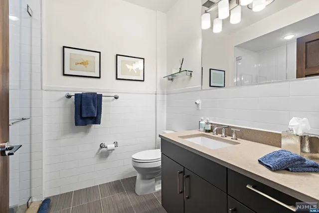 a bathroom with a sink a toilet and mirror