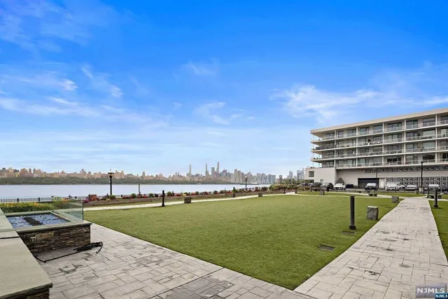 a view of a lake with a yard and large trees