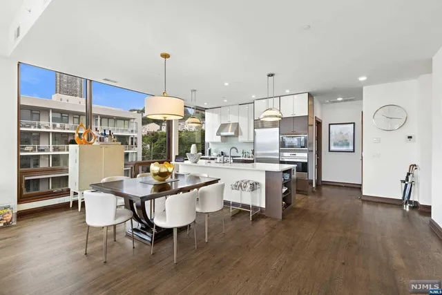 a kitchen with a dining table chairs and white cabinets
