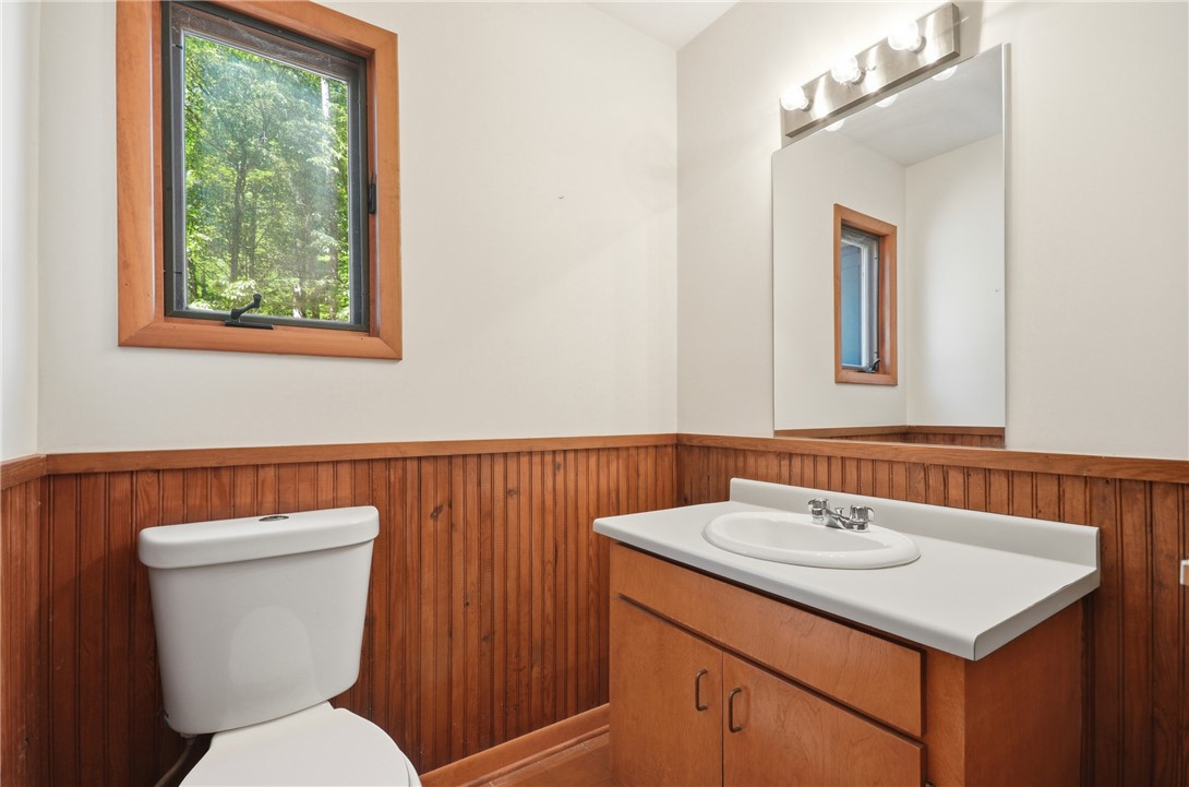 1298 Carradine Road Seneca, SC 29678 - Photo 11 of 43 A window-lit bathroom featuring warm wood paneling and a practical vanity.