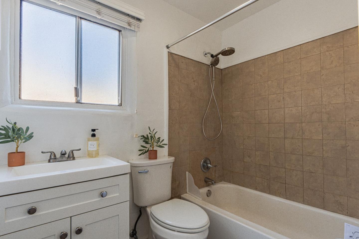 1915 Grandview Street Seaside, CA 93955 - Photo 26 of 29 a bathroom with a sink a mirror a toilet and bathtub
