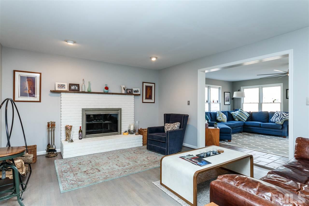3412 1st Place Raleigh, NC 27613 - Photo 2 of 25 Spacious room with woodburning brick fireplace, beautiful hardwoods and updated paint. Opens to sunroom.