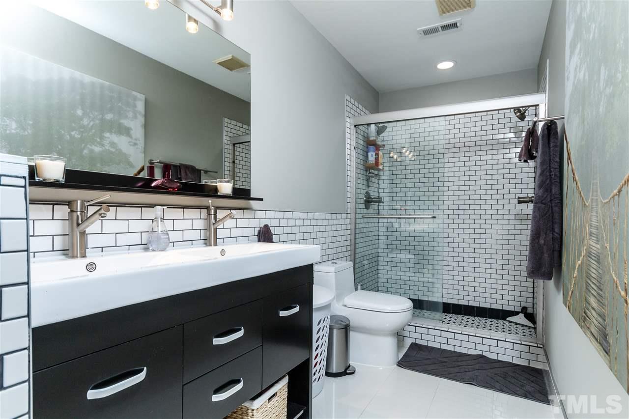 3412 1st Place Raleigh, NC 27613 - Photo 18 of 25 Such a relaxing feel to this home. Beautiful cabinets, tile and glass enclosed double shower. Double vanity and new decorative tile.