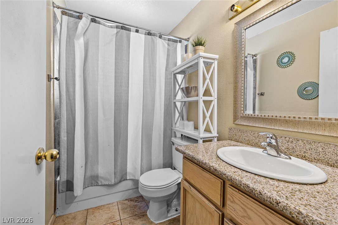 1624 Palmae Way Las Vegas, NV 89128 - Photo 12 of 18 This functional bathroom features a single vanity, a well-lit mirror, and a convenient shower-tub combination.