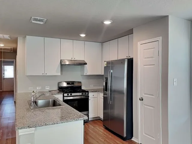 a kitchen with granite countertop stainless steel appliances and a refrigerator