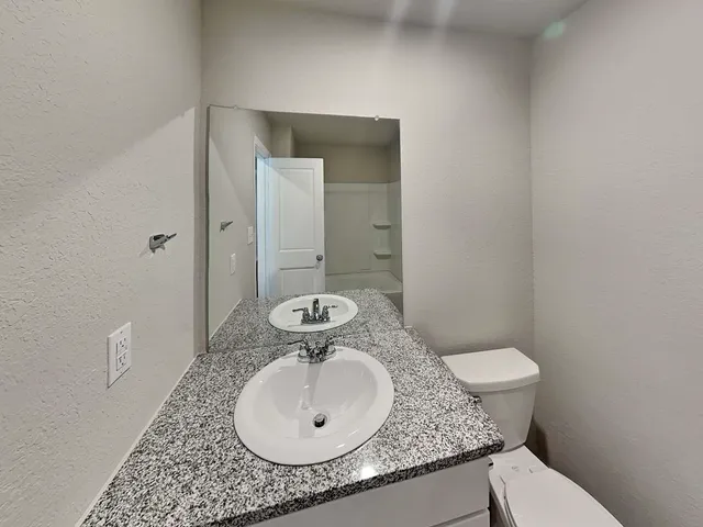 a bathroom with a granite countertop sink and a mirror