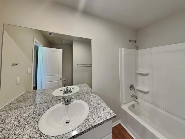 a bathroom with a granite countertop sink and a mirror