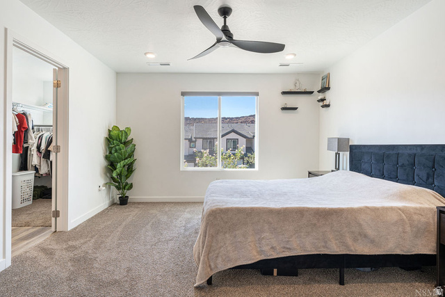 1693 Devils Gdn Lane Washington, UT 84780 - Photo 27 of 64 Carpeted bedroom featuring a large window, a ceiling fan with integrated lighting, and recessed lighting