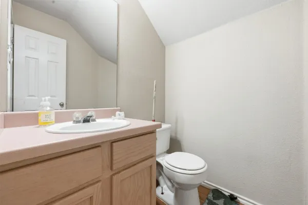 a bathroom with a toilet a sink and mirror