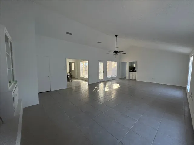 an empty room with stairs and wooden floor