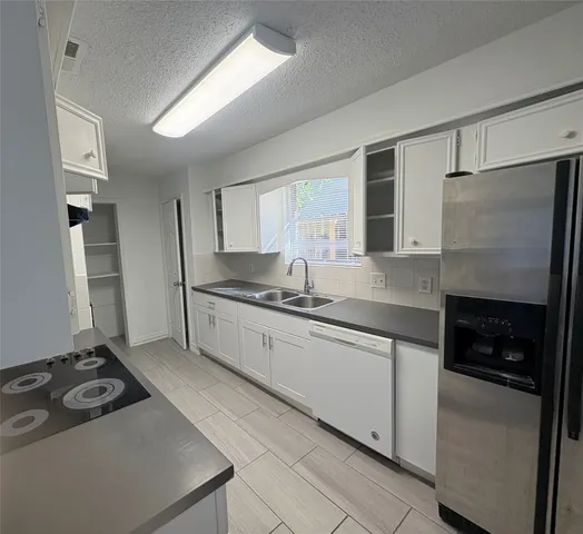 a kitchen with stainless steel appliances granite countertop a refrigerator and a sink