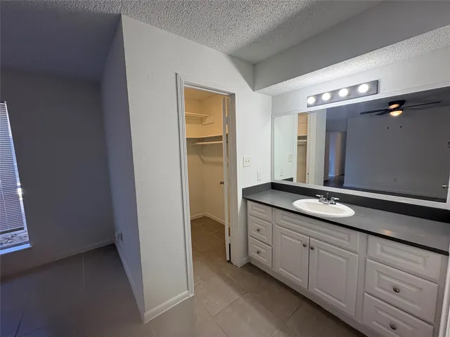 a spacious bathroom with a granite countertop sink and a mirror