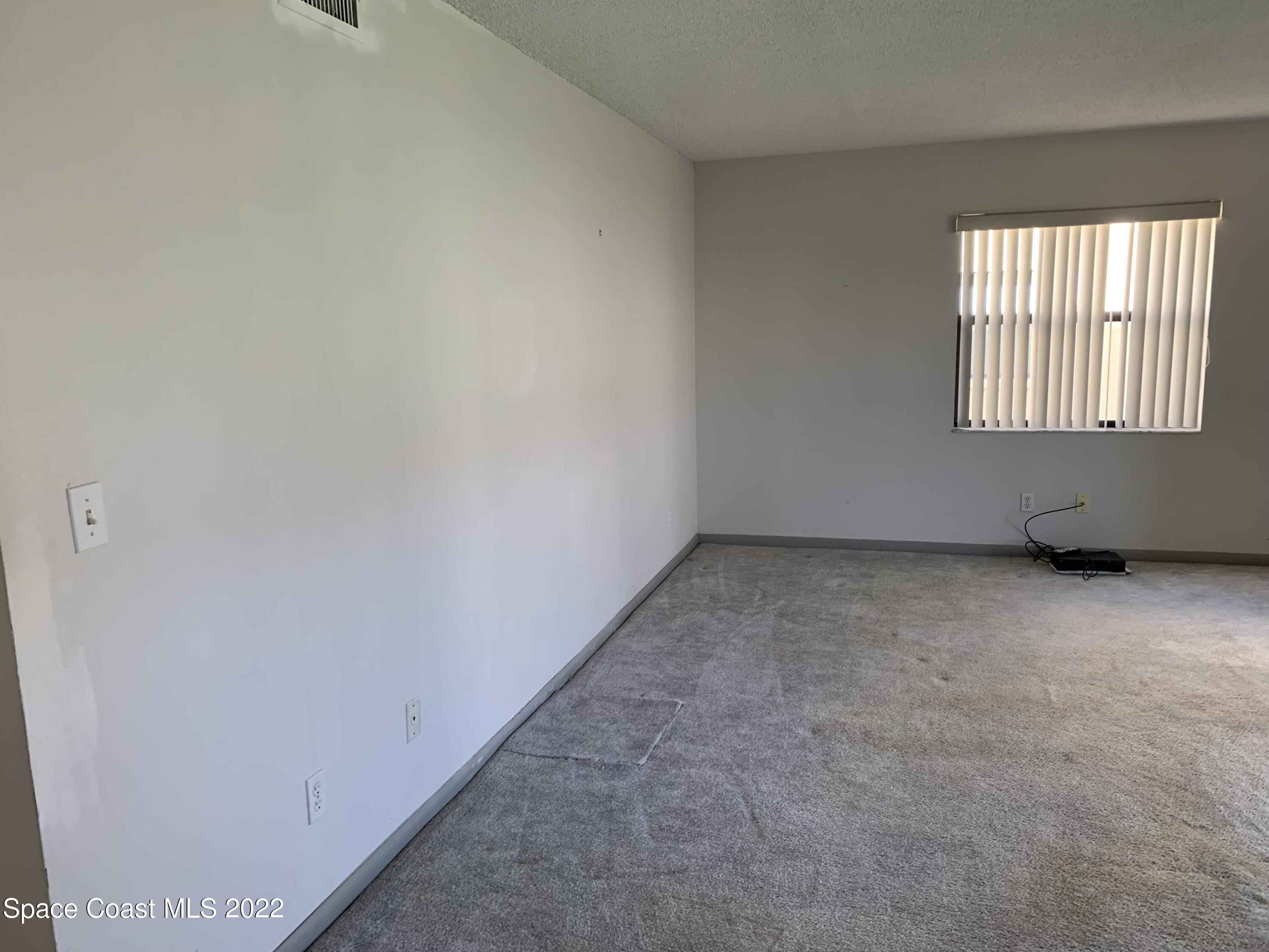 592 North Wickham Road, Unit 17 Melbourne, FL 32935 - Photo 3 of 13 an empty room with windows