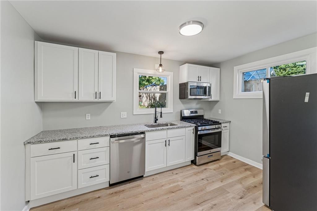 117 Owen Street McKees Rocks, PA 15136 - Photo 13 of 35 a kitchen with granite countertop a sink stove and refrigerator