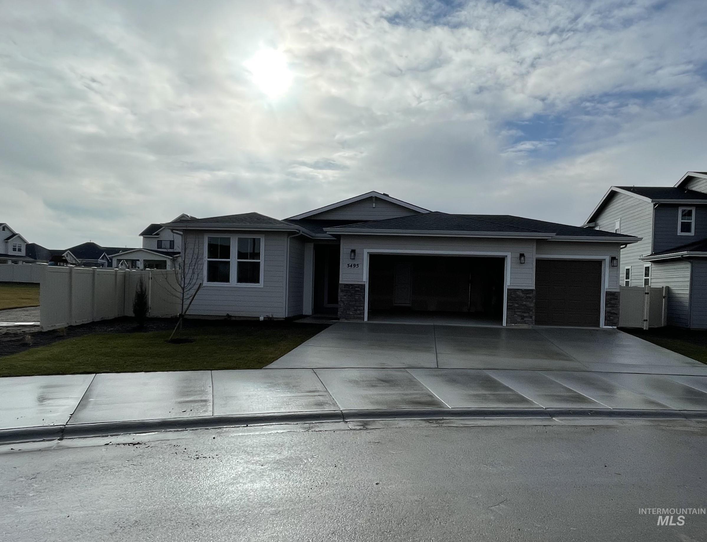 Single story home with an attached garage, concrete driveway, and stone siding