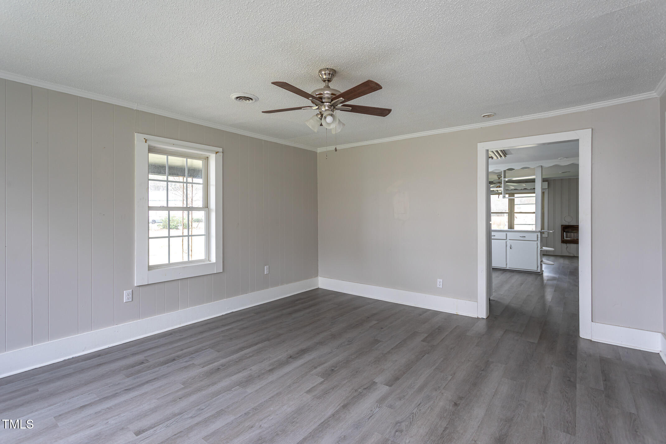 1239 Brogden Road Smithfield, NC 27577 - Photo 3 of 14 an empty room with wooden floor a ceiling fan and windows