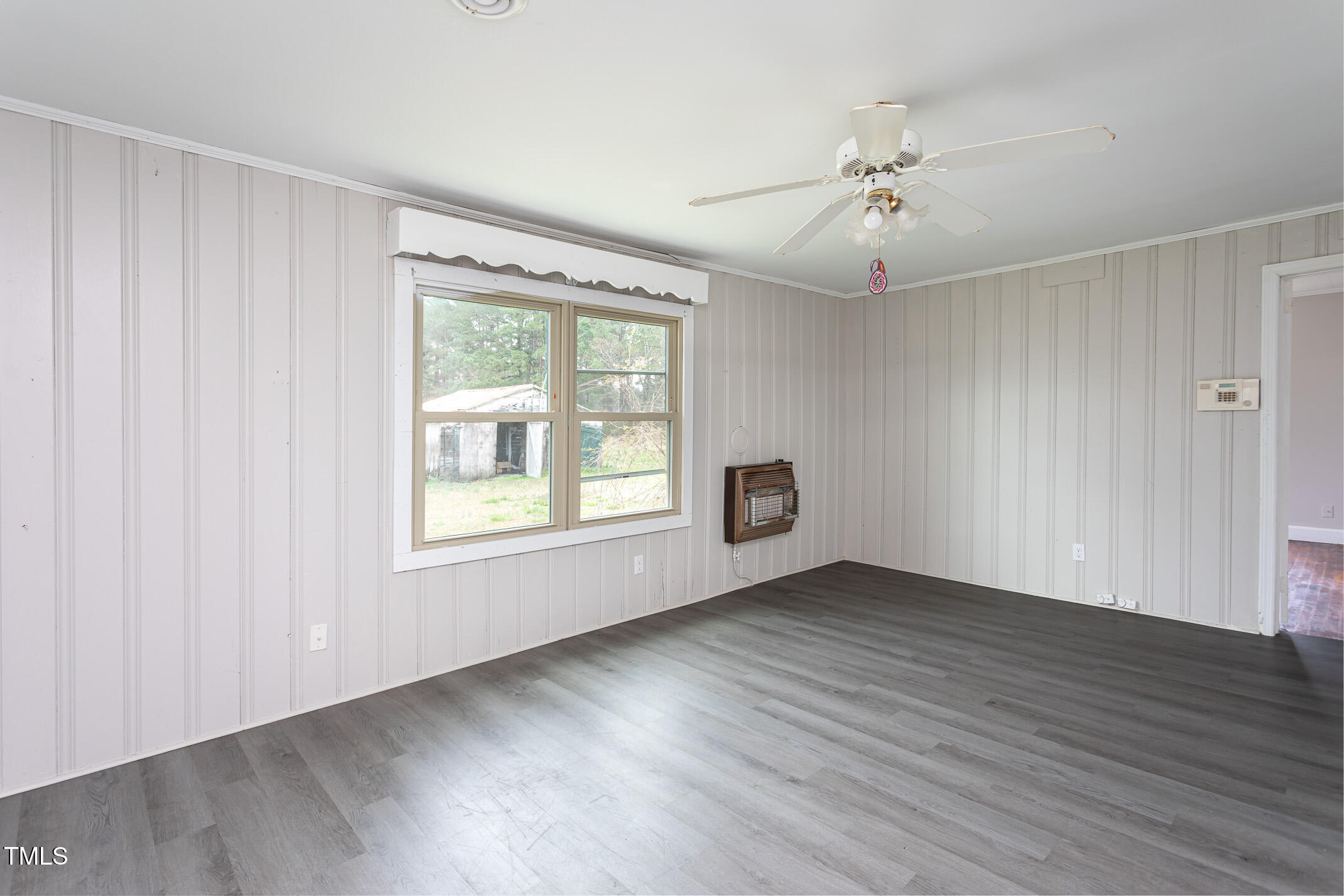 1239 Brogden Road Smithfield, NC 27577 - Photo 9 of 14 an empty room with wooden floor chandelier fan and windows