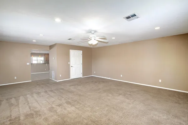 an empty room with kitchen and windows
