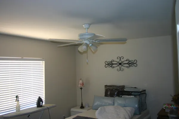 a view of an empty room with window and a ceiling fan
