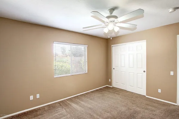 an empty room with a window and a fan
