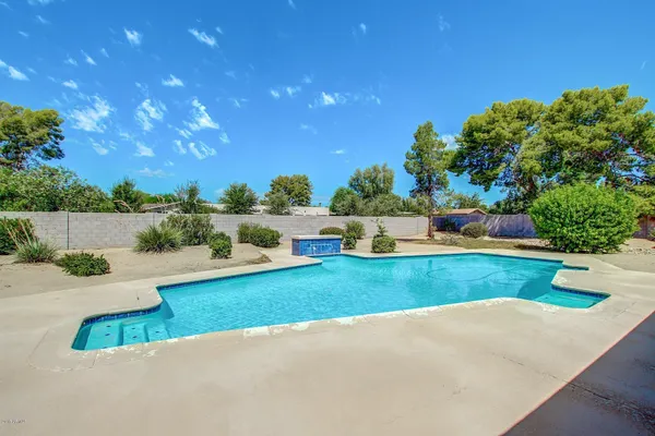 a patio with table and chairs and potted plants with wooden floor and city view