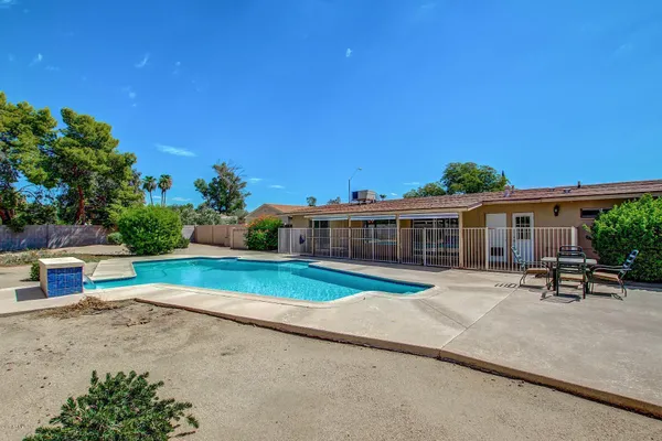 a view of a house with swimming pool and sitting area