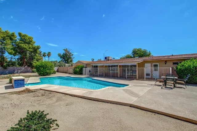 a view of a house with swimming pool and sitting area