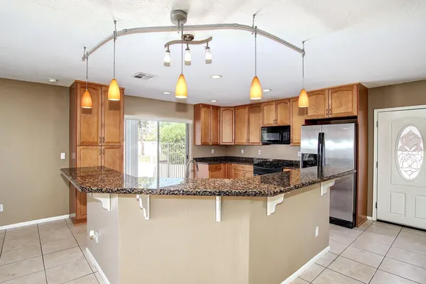 a kitchen with stainless steel appliances granite countertop a sink a stove and a wooden floors