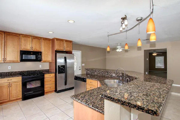 a kitchen with stainless steel appliances granite countertop a sink and a refrigerator