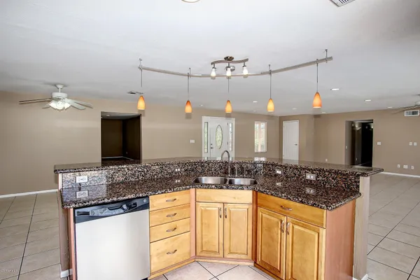 a kitchen with granite countertop a sink and cabinets