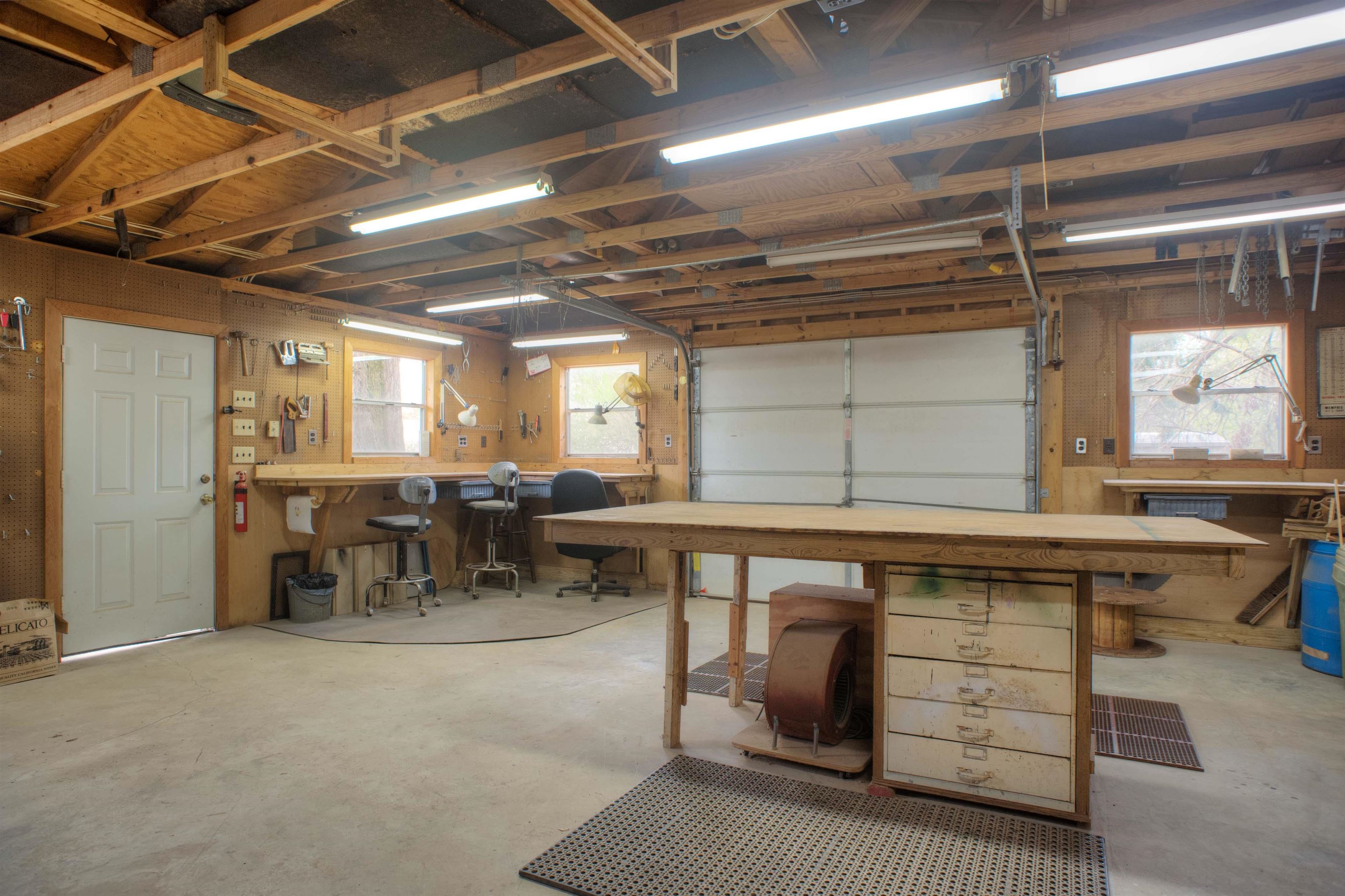 5270 Cole Road Memphis, TN 38120 - Photo 19 of 20 22x21 FABULOUS WIRED WORKSHOP - Spacious 22x11 Workshop Featuring Built-In Workbenches, Pegboard Storage, Ample Built-In Cabinets, and a Sliding Garage Door—Perfect for DIY Projects, Hobbies, or Extra Storage.