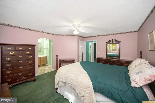 a spacious bedroom with a bed and a dresser next to a window