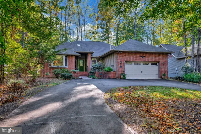 a front view of house with yard and trees in the background