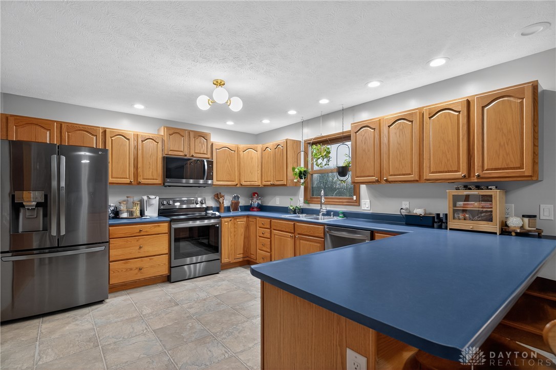 5264 Frazier-Guy Road Sidney, OH 45365 - Photo 13 of 51 This spacious kitchen offers ample cabinetry, modern appliances, and convenient meal preparation areas.