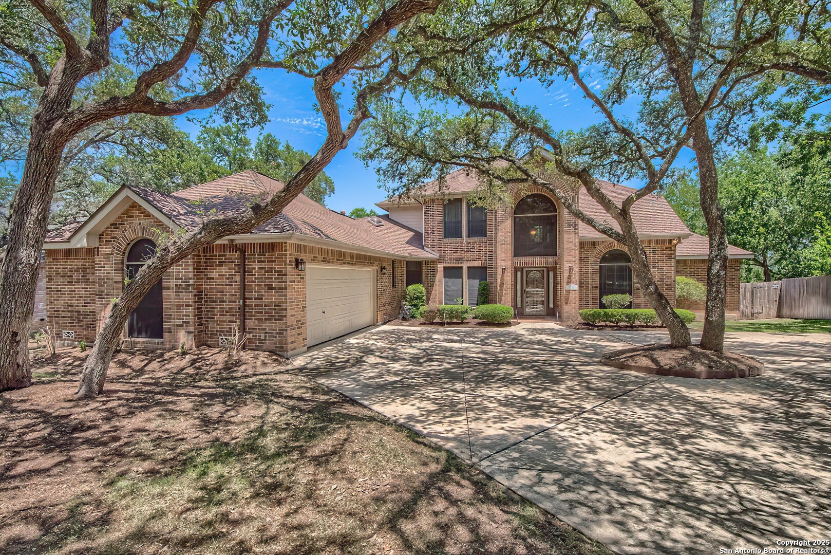 a view of a yard in front of a house with large tree