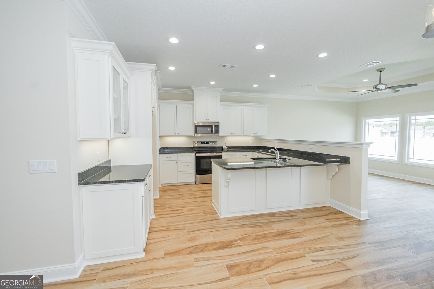 214 The Villas Way Kingsland, GA 31548 - Photo 3 of 47 a large white kitchen with wooden floor and stainless steel appliances
