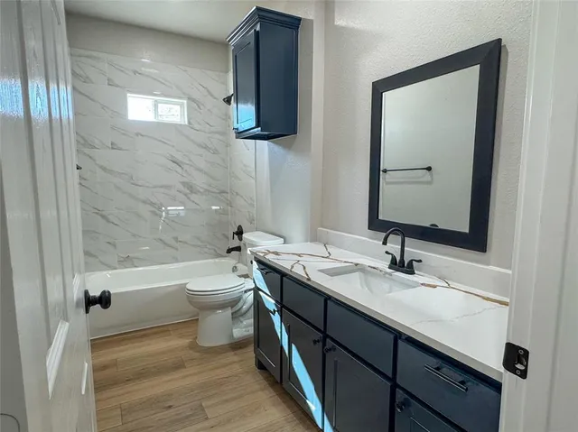 a bathroom with a double vanity sink toilet mirror and bathtub