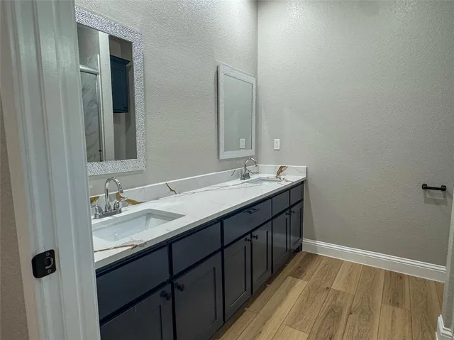 a bathroom with a double vanity sink and a mirror