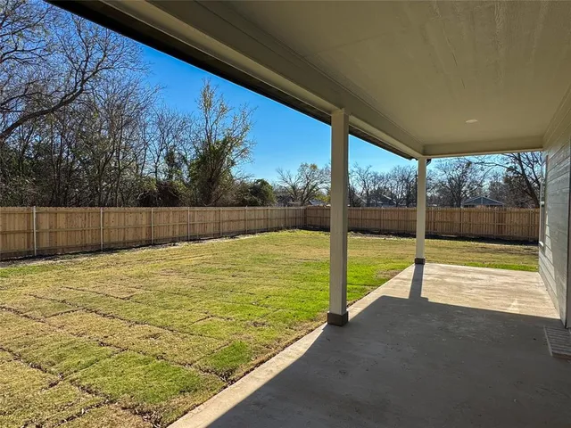 a view of an empty room with wooden floor and fence
