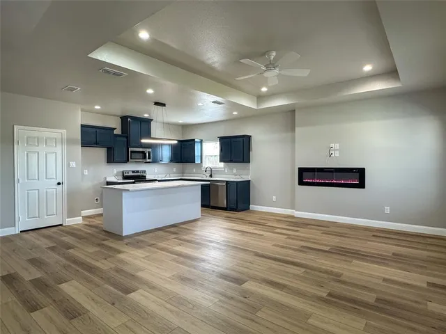a large kitchen with kitchen island a sink stainless steel appliances and cabinets