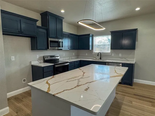a kitchen with stainless steel appliances wooden cabinets a sink and a stove