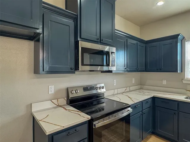 a kitchen with a sink a microwave cabinets and wooden floor