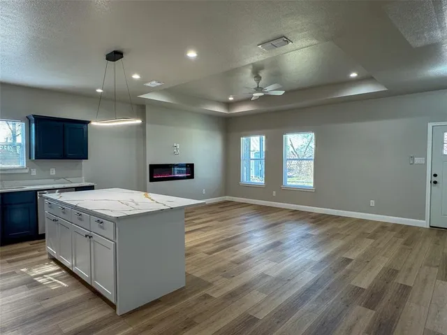 a kitchen that has a lot of cabinets in it and wooden floor